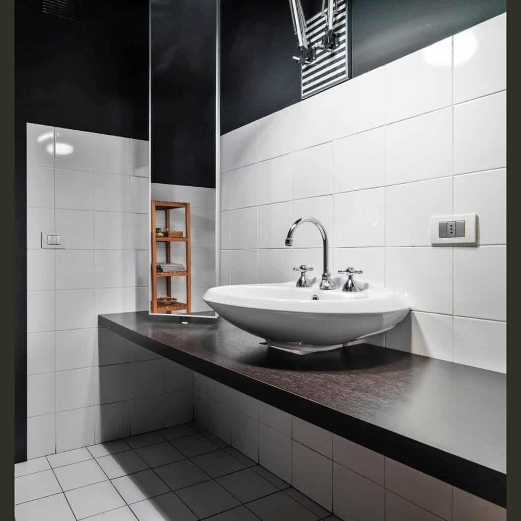Contemporary bathroom with white tiles and black accents by Struxure 28 Builders.