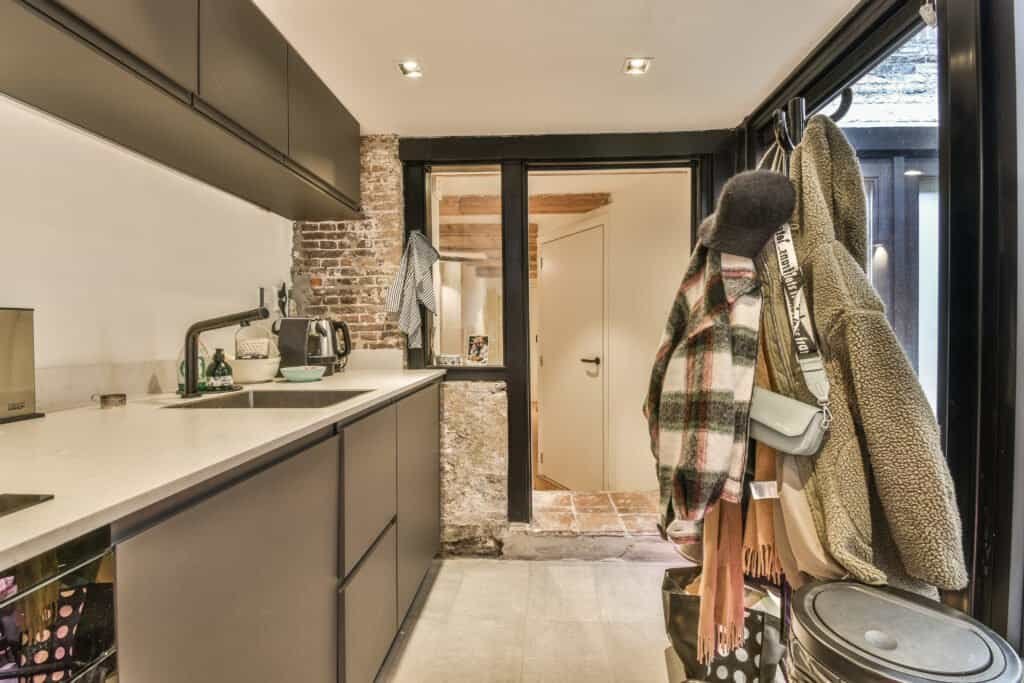 Contemporary kitchen with sleek cabinets and coat hooks at entryway.